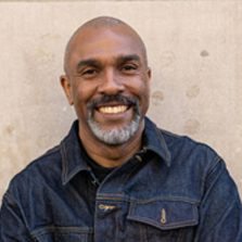Man wearing a denim jacket against a neutral background