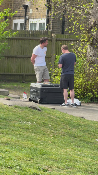 Co-founder, James, in a park conversing and giving a man a sample of Honest Scoop ice cream.